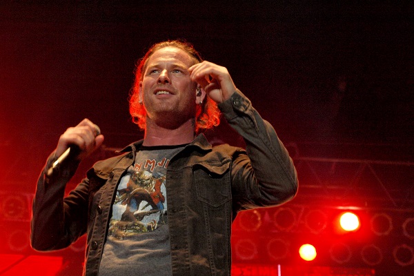 Corey Taylor performs live with Stone Sour amid red stage lighting.