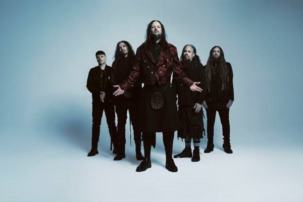 Photograph of nu-metal band Korn standing against a blue background.