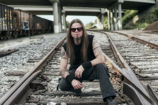 Todd La Torre of Queensryche, posted on railroad tracks on a dark day. La Torre has a new solo album out, "Rejoice in the Suffering."