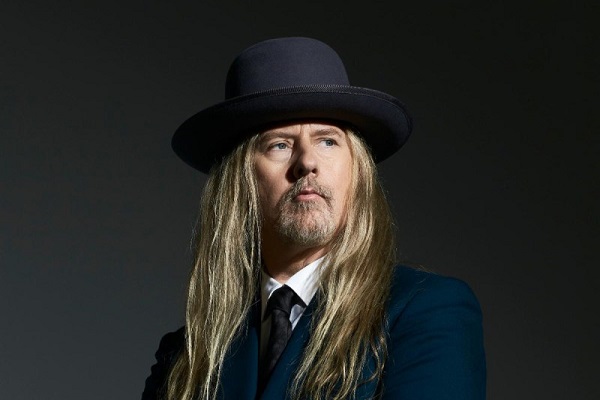 Jerry Cantrell of Alice in Chains posing for a press photo with a black top hat.
