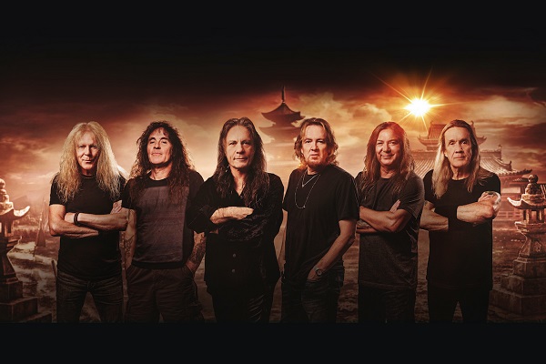 Metal band Iron Maiden standing amid a black and orange background.
