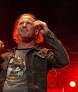 Corey Taylor performs live with Stone Sour amid red stage lighting.