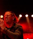 Corey Taylor of Stone Sour and Slipknot performing live amid a red-lit stage.