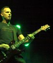 Mark Tremonti performs live amid dim green lighting.