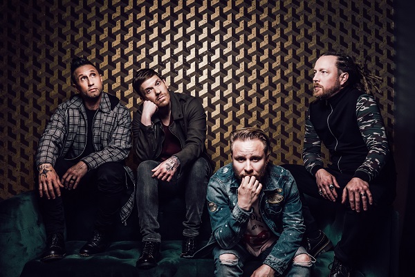A photo of rock band Shinedown posing against a light brown background.