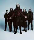 Photograph of nu-metal band Korn standing against a blue background.