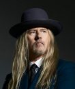 Jerry Cantrell of Alice in Chains posing for a press photo with a black top hat.