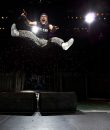 Bruce Dickinson of Iron Maiden jumping in the air during a live concert.