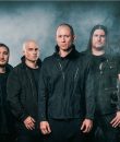 Trivium band photo, featuring the band standing amid a dark, smoky background.