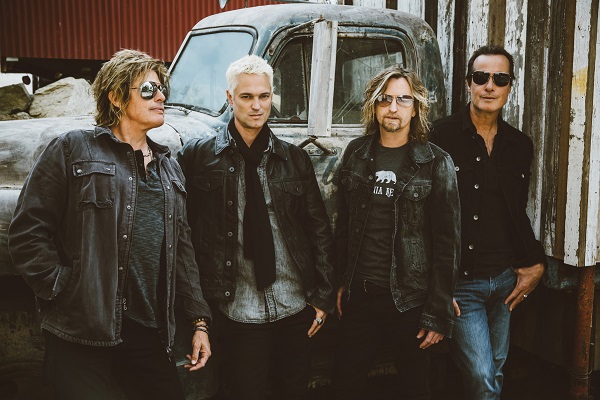 Photograph of Stone Temple Pilots standing in front of a classic car.