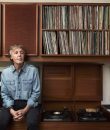 Photo of Paul McCartney sitting in a library.