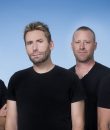 Rock band Nickelback standing with a blue background.