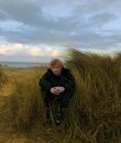 Ed Sheeran posing in a meadow