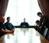 Image of a rock band at a table.