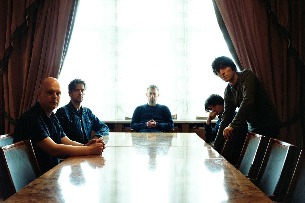 Image of a rock band at a table.